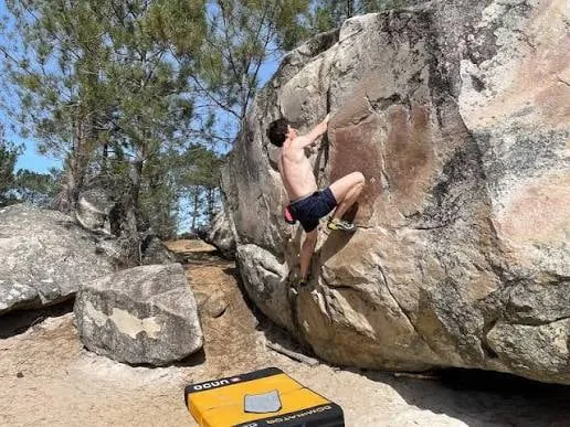 Mászó egy nagy sziklafalon, alatta a boulder-matrac